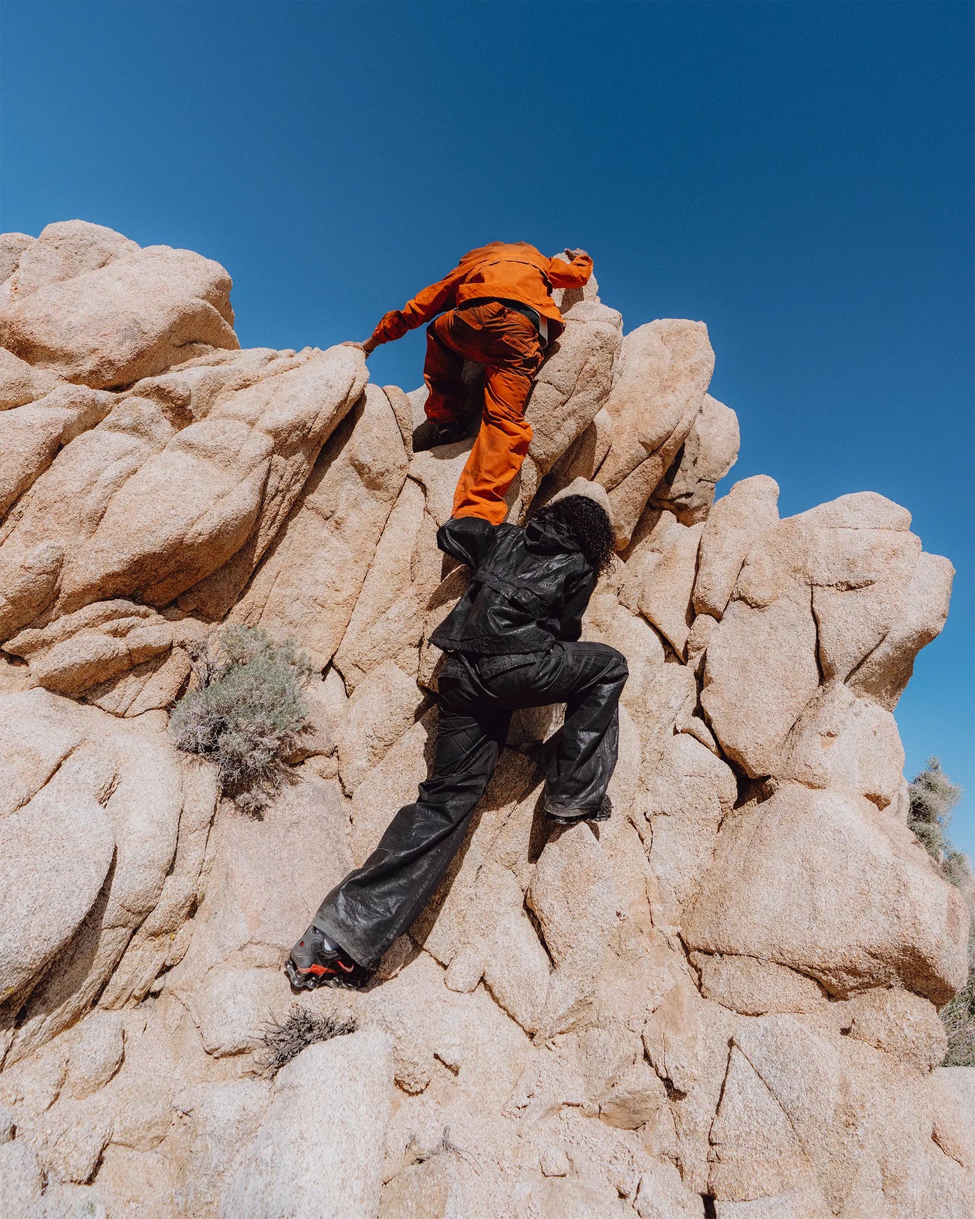 two men climbing a rock