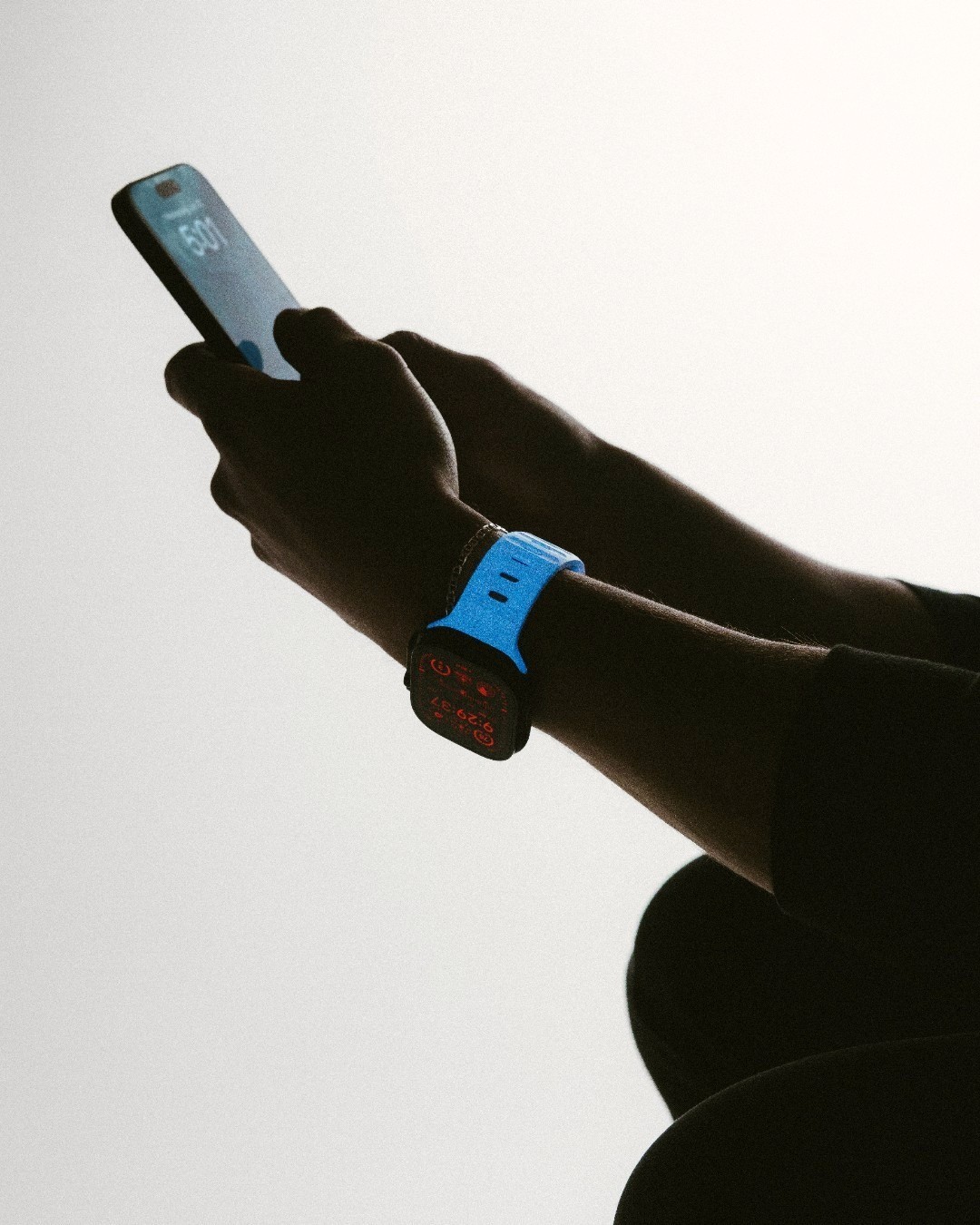 person holding a phone and typing while wearing a writswatch